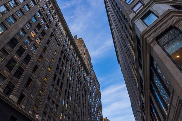 青い空に対するマンハッタンの高層ビルの美しいボトムアップビュー。アメリカだ。ニューヨーク. - 写真・画像