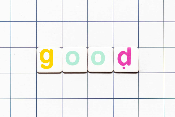 Colorful tile letter in word good on white grid background - Foto, afbeelding