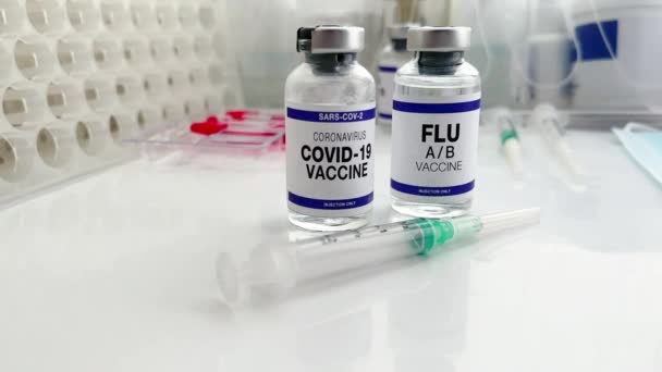 マイクロウイルスおよびインフルエンザウイルスのブースターショット用のインフルエンザA/BおよびCovid-19ワクチンバイアル。Sars-cov-2ウイルスとインフルエンザAの新しい変種のワクチン接種のためのコロナウイルスとインフルエンザショットワクチンボトル - 映像、動画