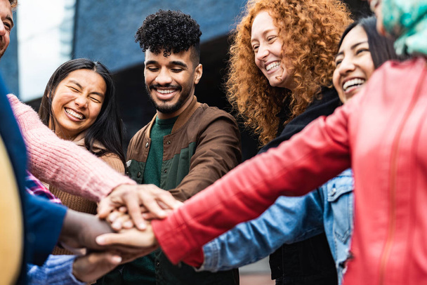 Glückliche multiethnische Freunde, die Spaß beim Händestapeln im Freien haben - Millennial Generation Konzept der Jugend - Foto, Bild