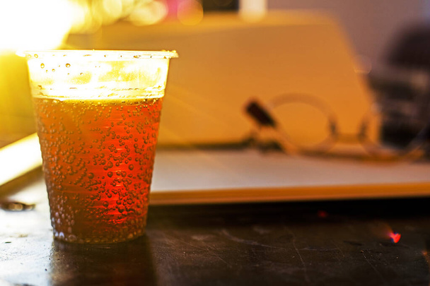 bebida energética en una taza transparente de plástico contra el sol. Horizonta - Foto, imagen