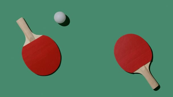 Raquetes vermelhas e um movimento de bola branca em uma mesa de tênis verde. Jogo de tabuleiro e conceito de entretenimento. Imagens FullHD de alta qualidade - Filmagem, Vídeo