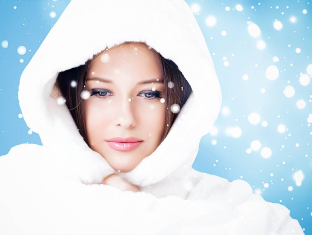 Happy holidays, beauty and winter fashion, beautiful woman wearing white fluffy fur coat, snowing snow on blue background as Christmas, New Year and holiday lifestyle portrait style - Photo, Image