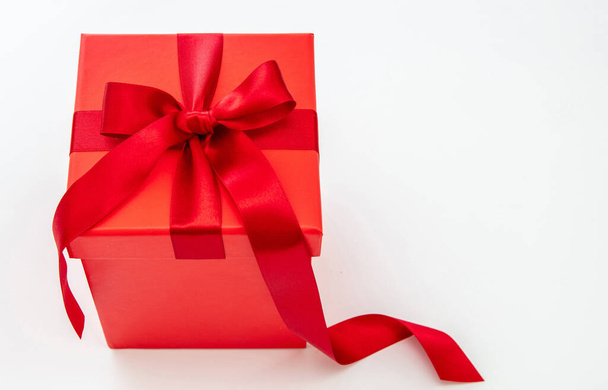 Kırmızı tutku kurdeleli kırmızı hediye kutusu beyaz arka planda izole edilmiş. Sevgililer Günü Xmas doğum günü hediyesi. Boşluğu kopyala - Fotoğraf, Görsel