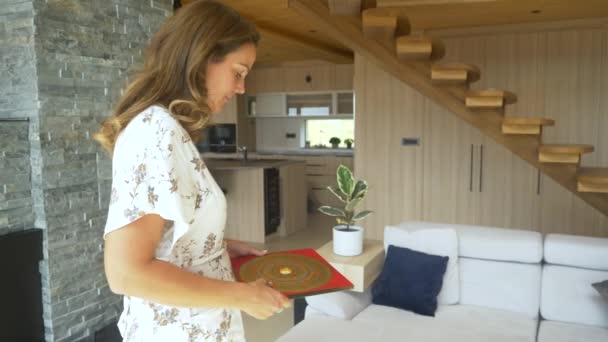 CLOSE UP: Pretty female feng shui practitioner using luo pan compass on location. Young woman doing feng shui analysis in home interior. Energy flow arrangements for balanced home living space design. - Footage, Video