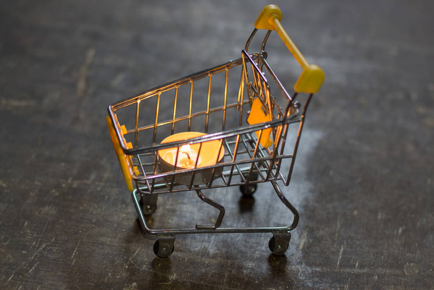 Burning candle in a supermarket cart. Blackout due to war in Ukraine - Foto, immagini