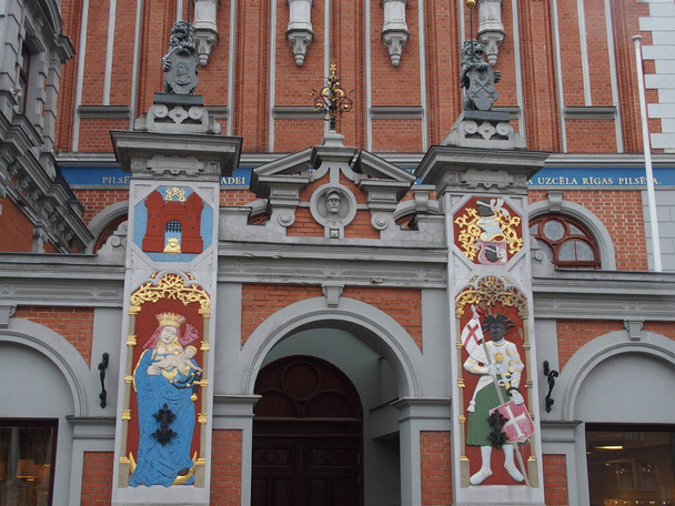 Kolorowe detale na fasadzie Domu Blackheadów w Rydze, Łotwa: po lewej Maryja i Dzieciątko Chrystusa, po prawej patron św. Maruricjusza - Zdjęcie, obraz