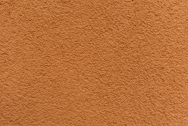 Textuur van helder oranje gepleisterde en geschilderde wand close-up - Foto, afbeelding