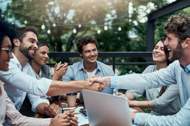 Η υποδοχή νέων μελών είναι πάντα ένα συν. επιχειρηματίες σφίγγουν το χέρι κατά τη διάρκεια συνάντησης σε καφετέρια - Φωτογραφία, εικόνα