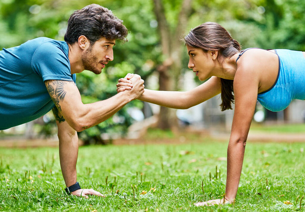 They rely on each other for support and motivation. a sporty young couple exercising together outdoors - 写真・画像