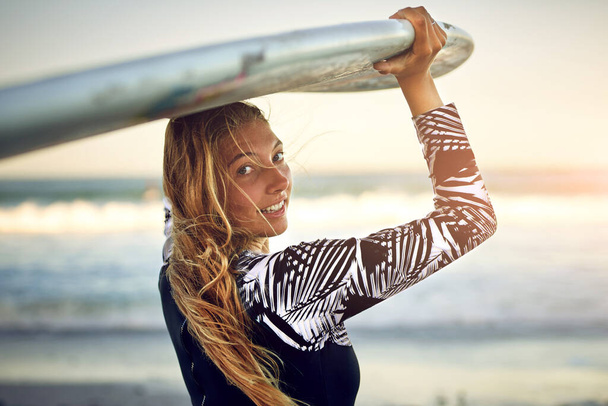 私と一緒に。海を見下ろす彼女のサーフボードで立っている魅力的な若い女性サーファーのレビューの肖像画 - 写真・画像