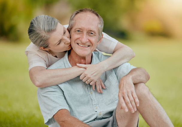 Senior couple, park and kiss for love, affection and care outside in a garden in summer. Mature, retired husband and wife bonding and being loving, caring and affectionate in romantic relationship. - Photo, Image