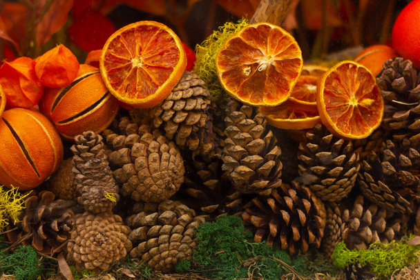 Φθινοπωρινή διακοσμητική σύνθεση κουκουναριών και αποξηραμένων πορτοκαλιών - Φωτογραφία, εικόνα