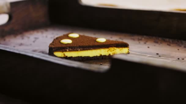 Chocolade taart met passievrucht op een houten dienblad met decoraties. - Video