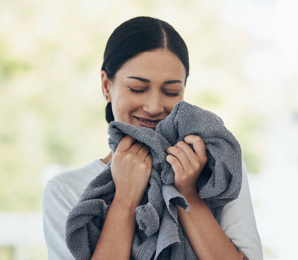 Laundry, fresh and woman smelling clean clothes with a smile, peace and calm in a house. Happy, young and smiling cleaner cleaning clothing, linen and towel in the morning with happiness in a home. - Photo, Image