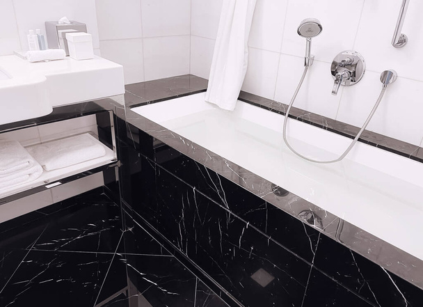 Diseño de interiores y materiales de decoración, baño de mármol negro de lujo en habitación de hotel de cinco estrellas, detalles - Foto, Imagen