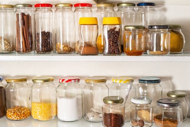 Vista frontal de algunos recipientes de vidrio con comida a granel en un estante de pared. Reutilización de envases de vidrio para productos industrializados. - Foto, Imagen