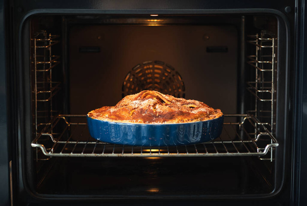 Homemade apple pie in a beautiful ceramic blue dish freshly baked in the oven. - Φωτογραφία, εικόνα