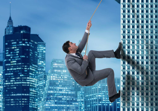 The businessman in challenge concept climbing skyscraper - Photo, Image