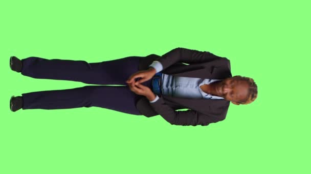 Vertical video: Office manager yawning and feeling exhausted at work, standing on green screen backdrop. Tired employee falling asleep and acting fatigued over full body greenscren, sleepy adult. - Footage, Video