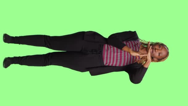 Вертикальне відео: Повне тіло жінки, що робить символ тайм-ауту t на фоні зеленого екрану, показує жест, що ламається або зупиняється руками. Стоїть на зеленому тлі з негативним символом відмови
. - Кадри, відео
