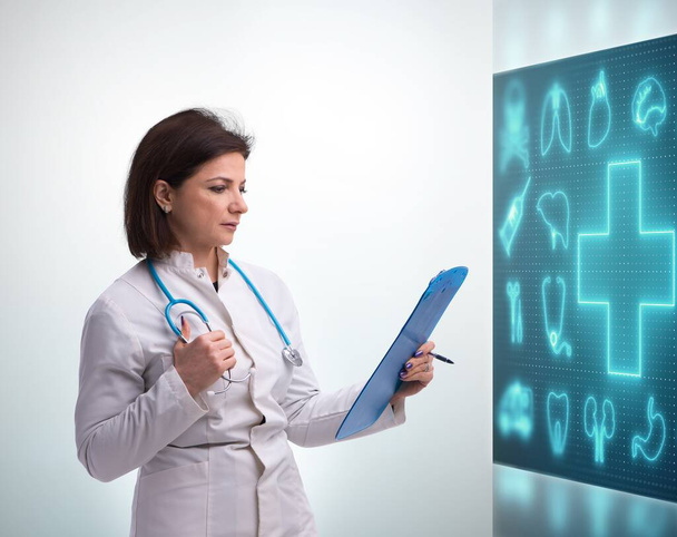 Женщина-врач в области телемедицины нажимает на сенсорный экран - Фото, изображение