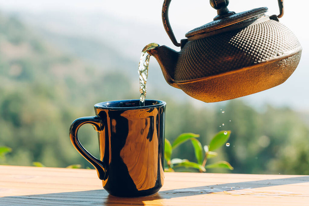 Teapot and cup outdoor on wooden background. Travel, outdoor breakfast, picnic, brunch concept - Fotografie, Obrázek