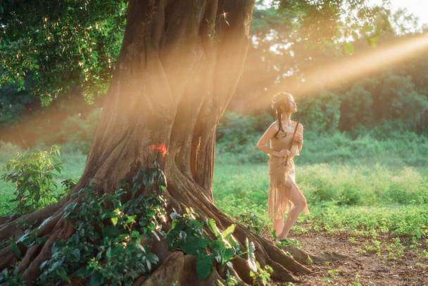 Nostalgic theme, girl playing flute under tree - Photo, Image