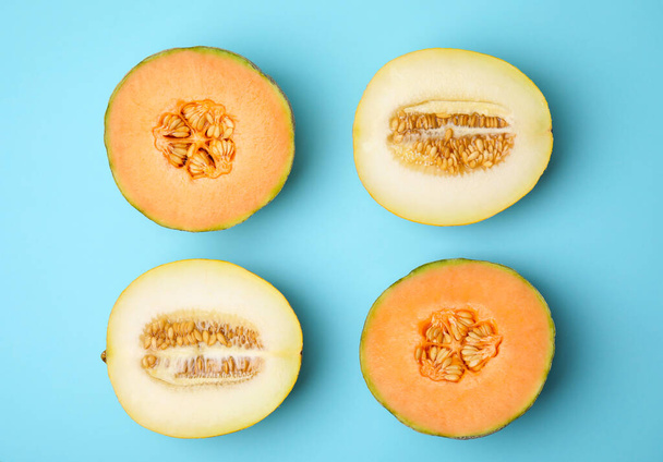 Tasty colorful ripe melons on light blue background, flat lay - Foto, Imagen