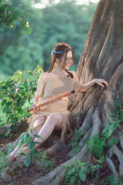 nostalgic theme, girl playing flute under tree - Фото, изображение