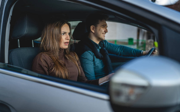 young woman in car with man girlfriend and boyfriend or husband and wife travel in the car female making face disappointed while man smile real people family travel concept copy space - Valokuva, kuva