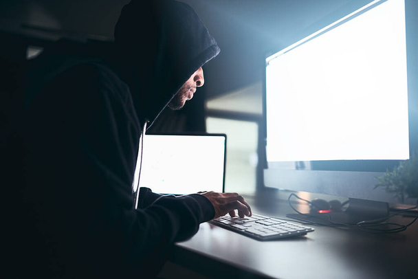 Die Hölle knackt diesen Code auf jeden Fall. Ein junger männlicher Hacker knackt im Dunkeln einen Computercode - Foto, Bild