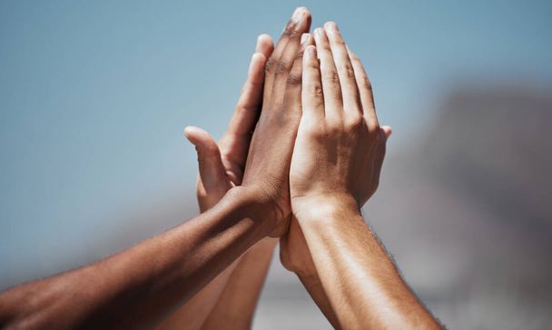 Team sports, diversity and hands doing high five in air for motivation, community and support. Teamwork, inspiration and multicultural group ready to start training, exercise and play in outdoor park. - Foto, Imagen