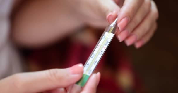 Womens hands hold a glass thermometer, a closeup, slowmotion. Temperature measurement, feverish symptom - Footage, Video