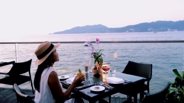 Donne thailandesi che fanno una cena romantica sulla spiaggia con cibo thailandese durante il tramonto, donne thailandesi asiatiche durante il tramonto che cenano sull'isola di Phuket Thailandia - Filmati, video
