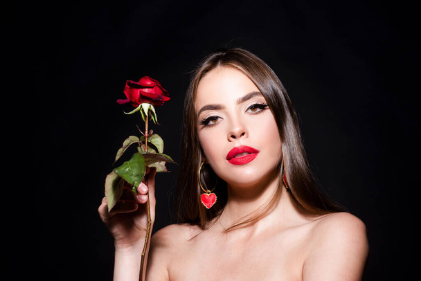 Fashion portrait of young beautiful woman with naked shoulder and red rose on black background - Фото, зображення