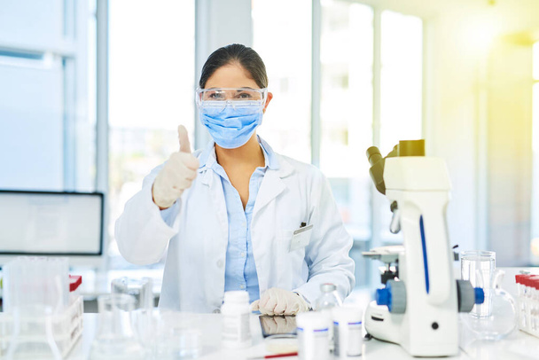 Committed to improving the world through science. Portrait of a young scientist showing thumbs up while working in a lab - Foto, Imagen