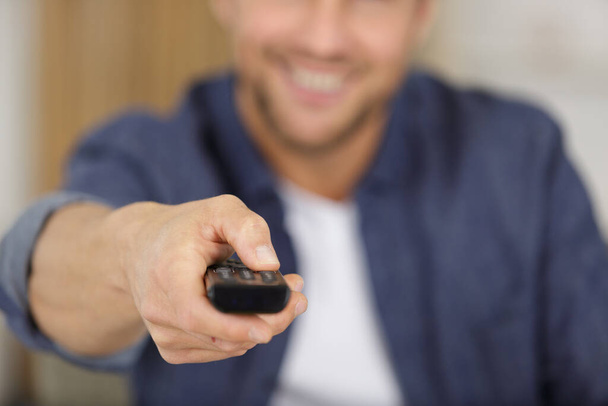 close up picture of man holding remote control - Foto, Imagen
