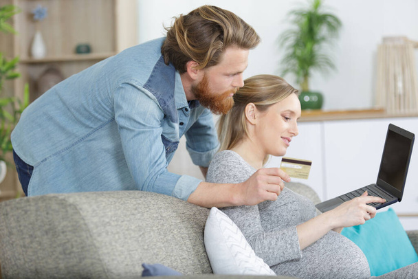 couple with pregnant woman using laptop computer together - Photo, Image