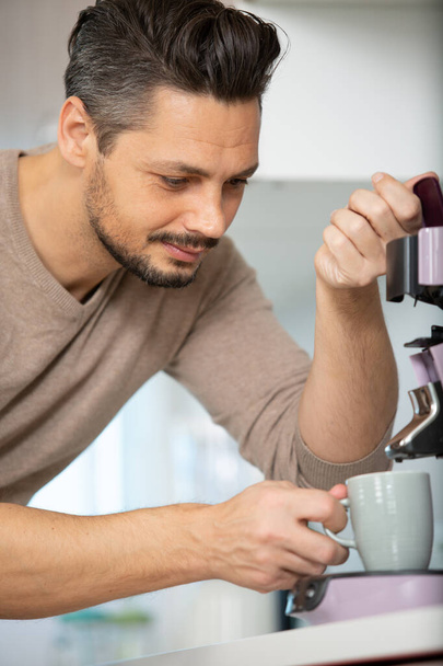 handsome man using coffee machine in kitchen - Фото, зображення