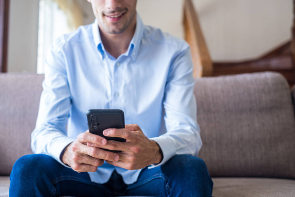 Close up of excited smiling man looking at phone screen, using mobile app, typing message in social network, reading news, email, male student chatting with friends, playing game, watching funny video   - Photo, Image