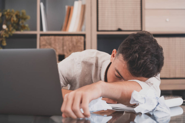 Close-up zakenman zet hoofd op gevouwen handen slapen op het werk. Overbelaste kantoormedewerker moe van routine eentonig papierwerk. Ongemotiveerde werknemer, slapeloosheid en chronisch vermoeidheidssyndroom  - Foto, afbeelding