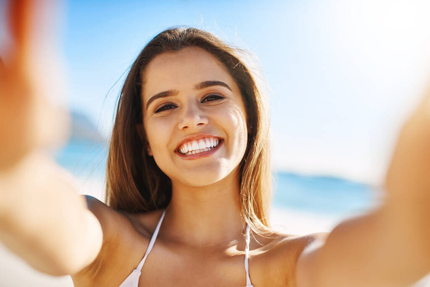 This is a day to remember. Closeup shot of a beautiful young woman spending some time at the beach - Foto, imagen