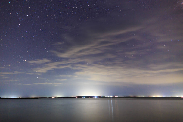 Starry sky on the lake. Night landscape. Sky with clouds. Kyrgyzstan - Photo, Image