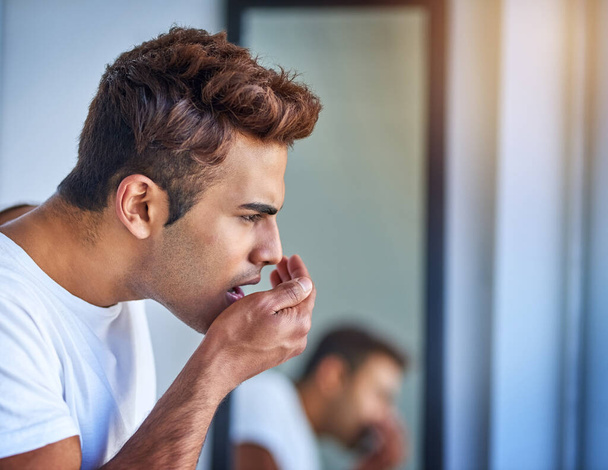 To je vůně ode mě. pohledný mladý muž čichající jeho dech během jeho ranní péče rutiny - Fotografie, Obrázek