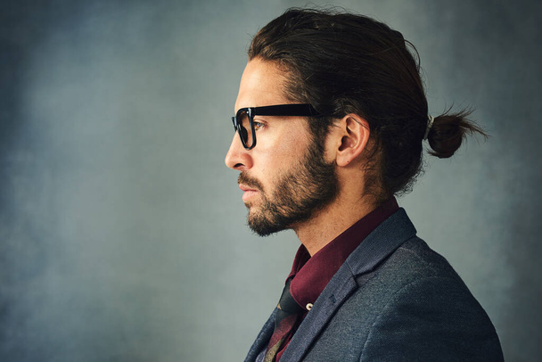 Proflie on style. Studio profile shot of a stylishly dressed handsome young man with a ponytail - Fotografie, Obrázek