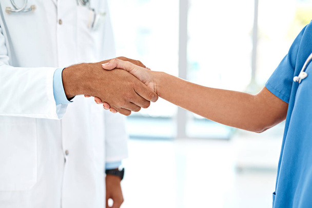 Collaboration goes a long way in medicine. two unidentifiable healthcare practitioners shaking hands in the hospital foyer - Foto, Imagem