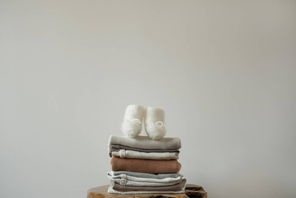Cute eco cotton stylish Scandinavian newborn baby clothes, socks stack. Pastel pale neutral colours baby fashion basic bodysuits and socks. Online fashion store, online shopping branding concept. - Φωτογραφία, εικόνα