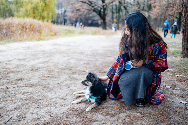Cane cucciolo con il suo proprietario a piedi nel parco forestale. - Foto, immagini