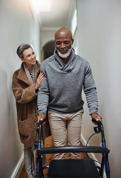 Прямо поруч з вами, коли ми старіємо. старша жінка допомагає чоловікові ходити зі своїм ходунком
 - Фото, зображення